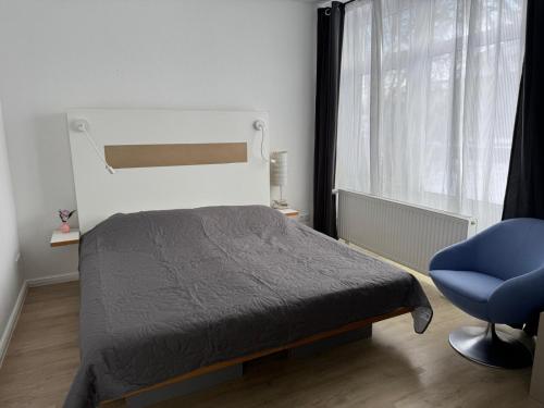 a bedroom with a bed and a blue chair at Dream Holiday Haus in Uetersen