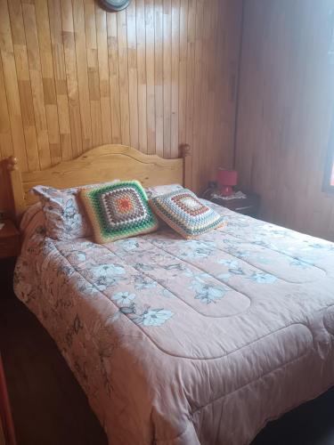 a bed with two pillows on top of it at Cabañas Abrumax in Hornopiren