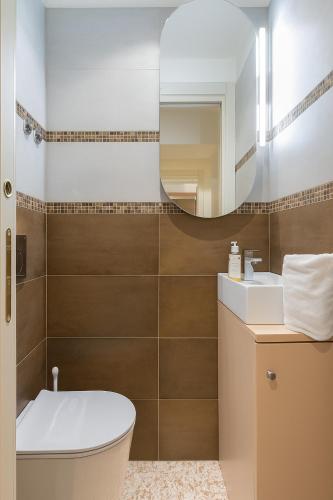 a bathroom with a toilet and a sink and a mirror at Canonica Apartment - Eclettica Hospitality in Venice