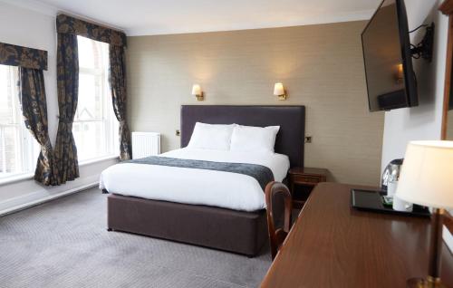 a hotel room with a bed and a desk at George Hotel by Greene King Inns in Huntingdon