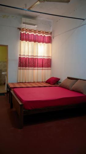 a bedroom with two beds in front of a window at RooLi Harbour Inn-Trincomalee in Trincomalee