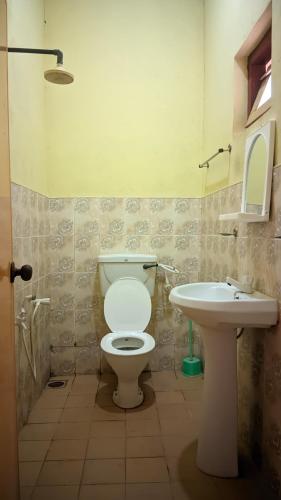 a bathroom with a toilet and a sink at RooLi Harbour Inn-Trincomalee in Trincomalee