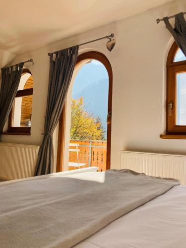 a bedroom with a bed and an open window at Mountain View House - Panoramic! in Gozd Martuljek