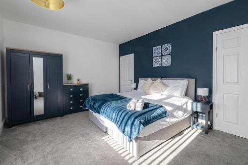 a bedroom with a bed with a blue wall at The Relaxation Station in Bishop Auckland