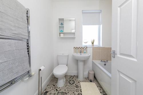 a white bathroom with a toilet and a sink at The Relaxation Station in Bishop Auckland