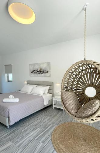 a bedroom with a bed and a rattan chair at DL Santorini in Monolithos