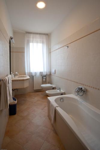 a bathroom with a tub and a toilet and a sink at Hotel Dei in Cascia