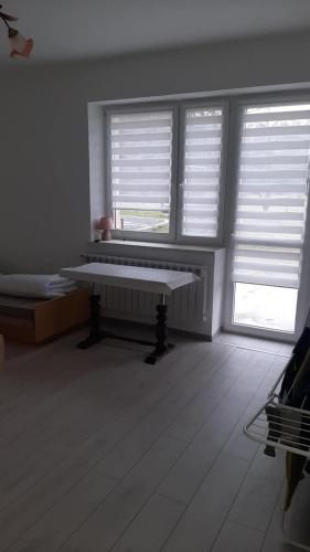 a white room with two windows and a bench at Pokoje do wynajęcia w domku in Ryczówek