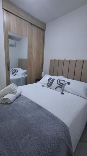 a bedroom with a large white bed with a mirror at Apartamento en Roldanillo in Roldanillo