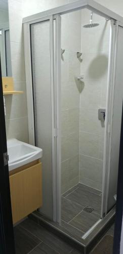 a shower with a glass door next to a sink at Apartamento en Roldanillo in Roldanillo
