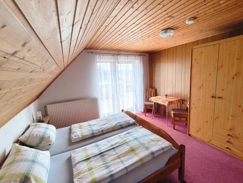 a attic room with two beds and a table at Gästehaus Heuchert in Meersburg
