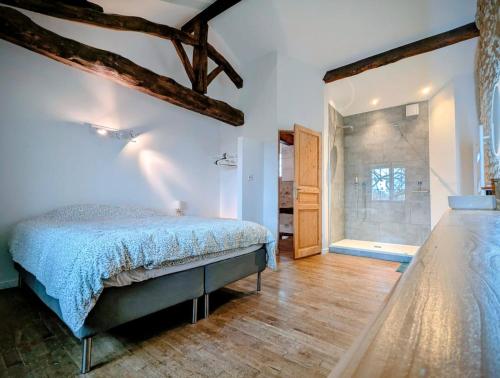 a bedroom with a bed and a large window at Les Côtes - Charming holiday home with heated swimming pool in Palluaud