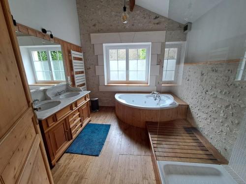 a large bathroom with two sinks and a tub at Les Côtes - Charming holiday home with heated swimming pool in Palluaud