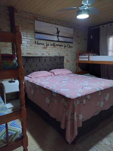 a bedroom with a bed with a pink bedspread at Pousada 03 do vô Bi in São Francisco do Sul