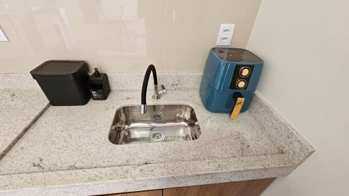 a kitchen counter with a sink and a toaster at Chalés Brisas do Lago Capitólio in Capitólio