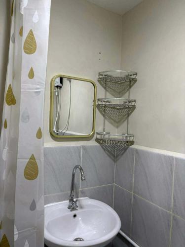 a bathroom with a sink and a mirror at Studio Stay at Saekyung Condominium in Lapu Lapu City