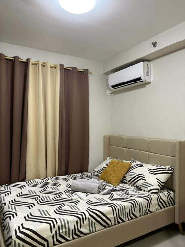 a bedroom with a bed with a zebra print sheets at Studio Stay at Saekyung Condominium in Lapu Lapu City