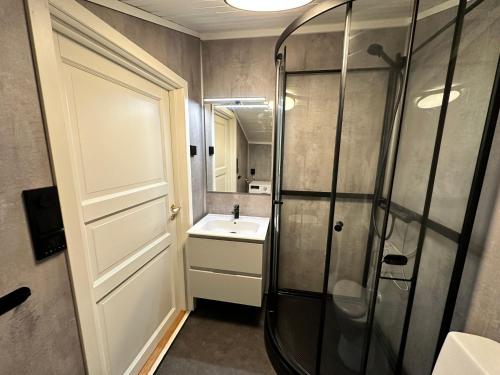 a bathroom with a shower and a sink at Sørlandets paradis in Svenevik
