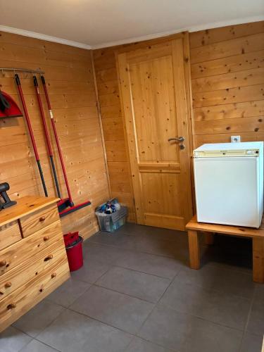 a small room with a refrigerator and a door at Waldhaus Wangen in Burg-Reuland