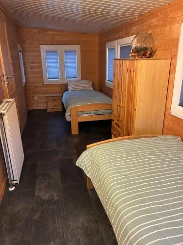 a bedroom with two beds in a wooden cabin at Waldhaus Wangen in Burg-Reuland
