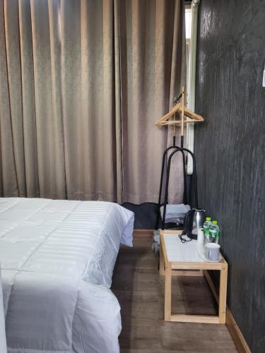 a bedroom with a bed and a table with a lamp at auntythong house in Bangkok
