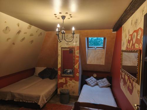 a small room with two beds and a chandelier at Chillout-House in Mińsk Mazowiecki