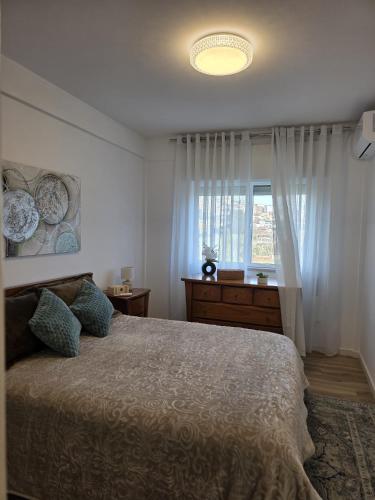 a bedroom with a large bed and a window at Ninho D`ouro in Peso da Régua