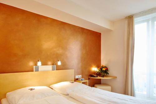 ein Hotelzimmer mit einem Bett und einem großen Fenster in der Unterkunft Town Hotel Wiesbaden - kleines Privathotel in Bestlage in Wiesbaden