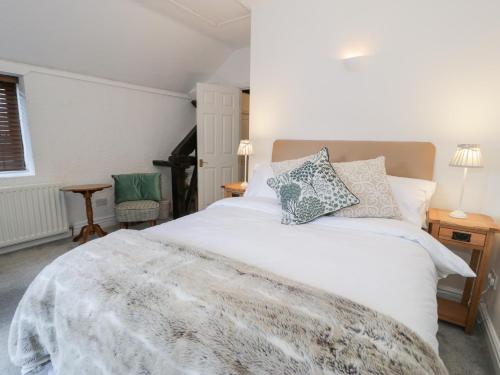 a bedroom with a white bed with pillows on it at Ivy Cottage in Abergele