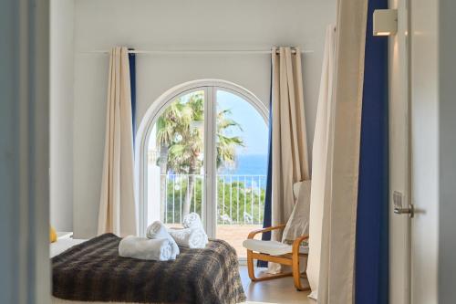 a bedroom with a bed and a view of the ocean at Villa Mar Gran in Cacla D'or