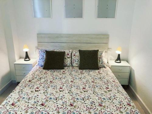 a bedroom with a bed with two lamps on it at PLAYA Y PISCINA Intiyan PONDOS in Almuñécar