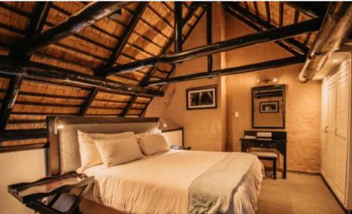 a bedroom with a bed and a desk in it at Mount Sheba Rainforest & Resort in Pilgrim's Rest