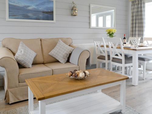a living room with a couch and a table at Pine View Cottage in Filey
