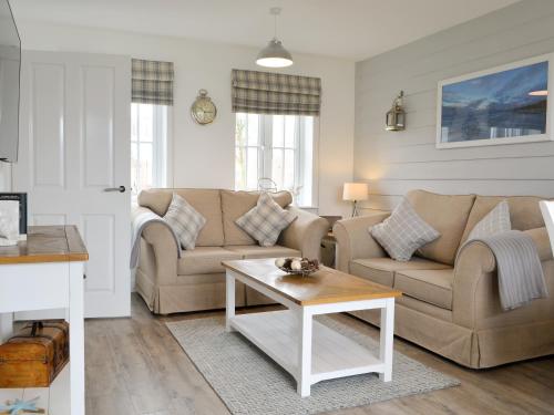 a living room with two couches and a coffee table at Pine View Cottage in Filey