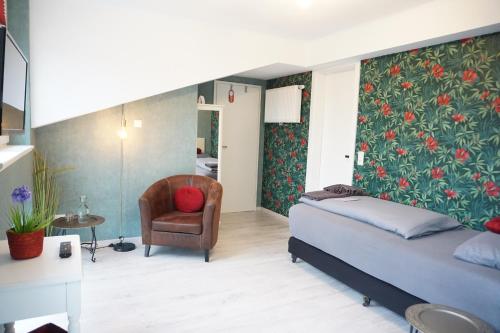 a bedroom with a bed and a chair at Hotel Groote Engel in Emlichheim