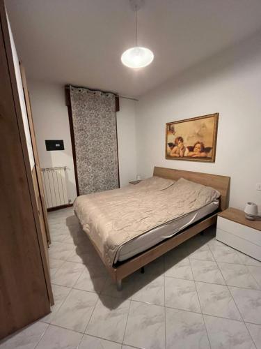 a bedroom with a bed and a painting on the wall at Nuovo Sile in Cavallino-Treporti