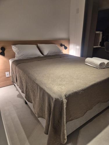 a bedroom with a large bed with white sheets and pillows at Apto Stúdio Liberdade novíssimo in São Paulo