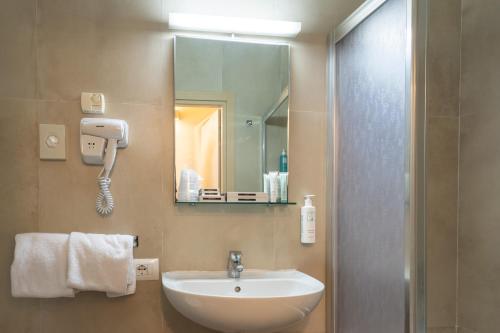 a bathroom with a sink and a mirror at Albergo Firenze in Florence