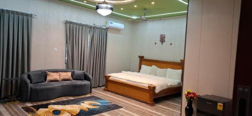 a bedroom with a bed and a chair in it at Pelican VVIP Villa in Wa