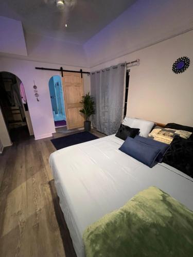 a bedroom with a large white bed with blue pillows at Alaynah's Place in Brunswick