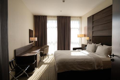 a hotel room with a bed and a desk at Premier Sofia Airport Hotel in Sofia