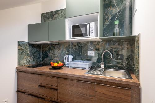 a kitchen with a sink and a microwave at Villa Liberty 2 in Cavtat