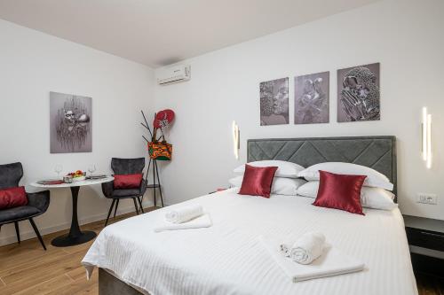 a bedroom with a large white bed with red pillows at Villa Liberty 2 in Cavtat