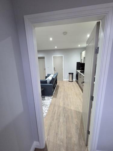a living room with a blue couch and a kitchen at Easy access to manchester airport &city centre in Manchester