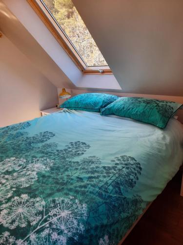 a bedroom with a bed with a blue comforter at The Wee Loft in Carrbridge