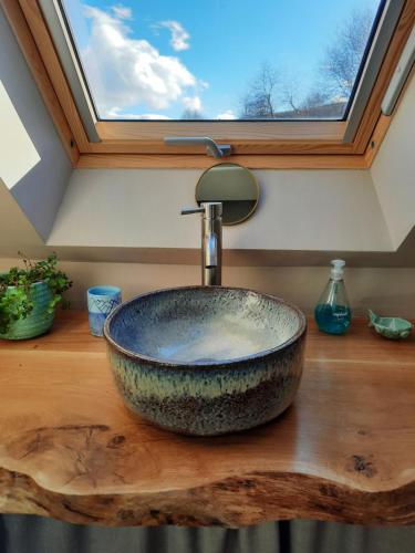 a bathroom sink with a large stone bowl at The Wee Loft in Carrbridge