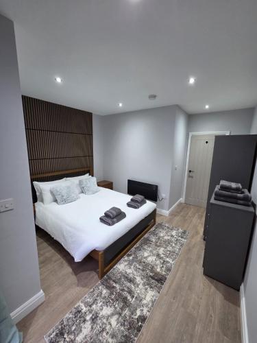 a bedroom with a large white bed and a rug at Easy access to manchester airport &city centre in Manchester