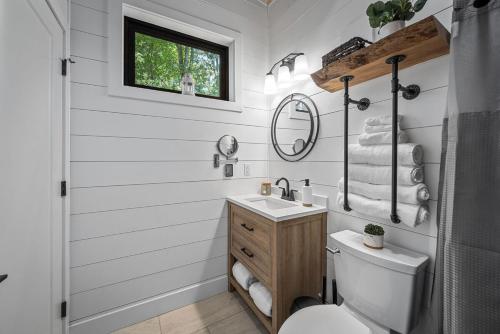 a bathroom with a toilet and a sink and a mirror at NEW - Treehouse - Dogwood in Jonesburg