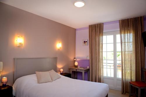 - une chambre avec un lit et une grande fenêtre dans l'établissement Logis Chez Germaine, à Geüs-d'Oloron