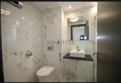 a white bathroom with a toilet and a sink at résidence 2 chambres avec piscine proche mer in Orihuela Costa